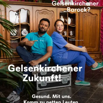 Zwei Personen sitzen auf einem Case in einem Wohnzimmer